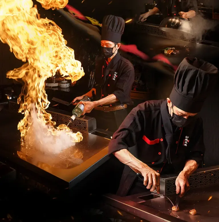 Đội ngũ THE GU thao tác trên mặt bàn Teppanyaki với lửa và dụng cụ nấu