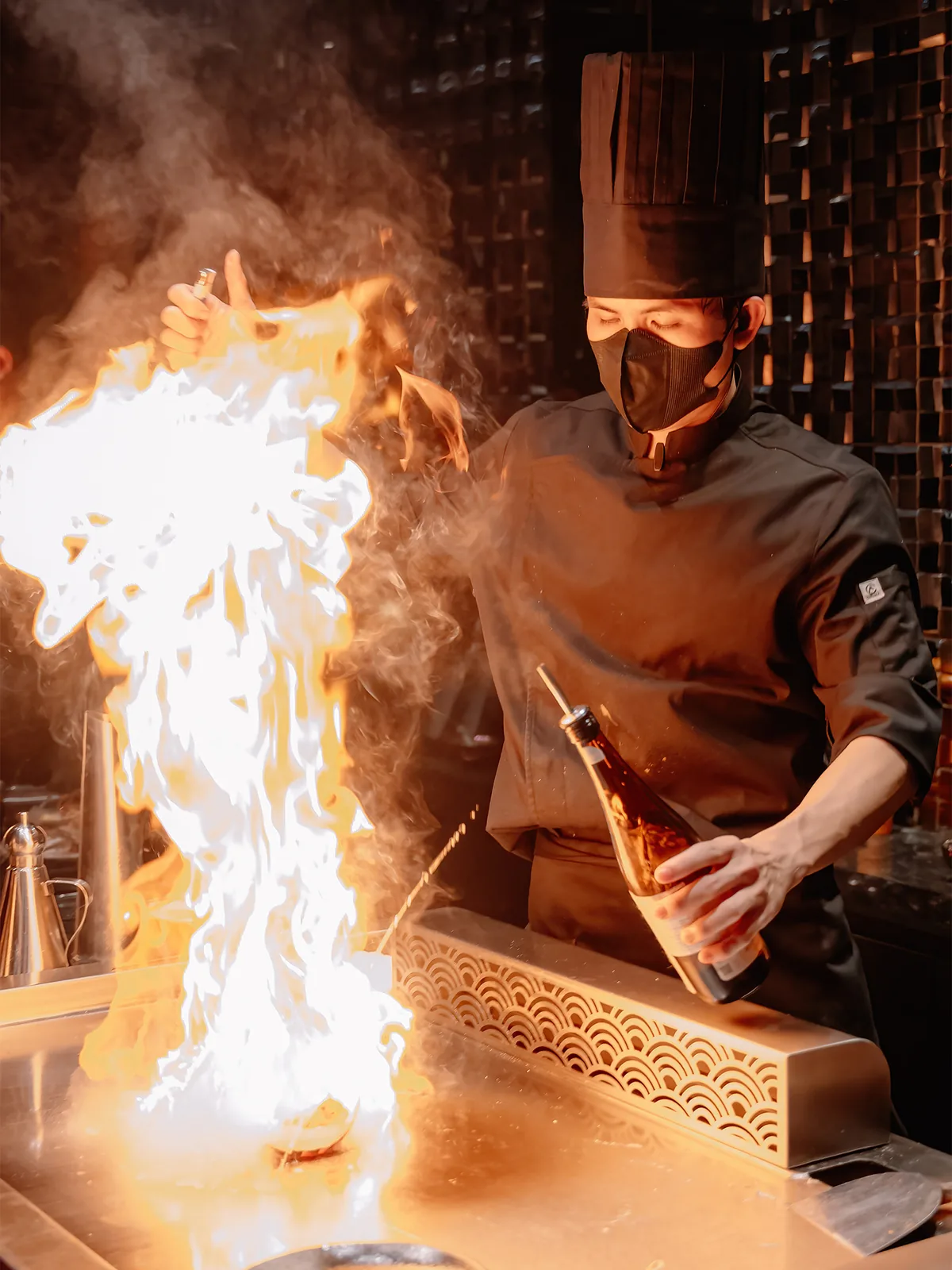 A THE GU chef controlling flame on the teppan