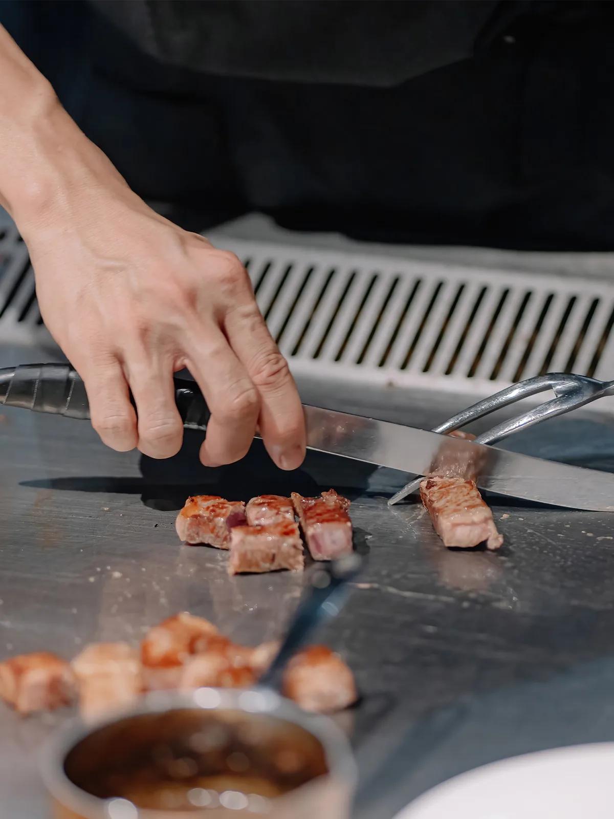 THE GU chef slicing meat on the teppan